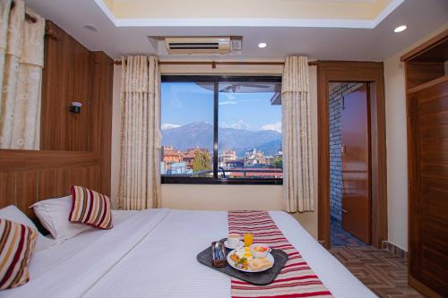 a bedroom with a bed with a tray of food on it at Hotel Crystal Palace in Pokhara