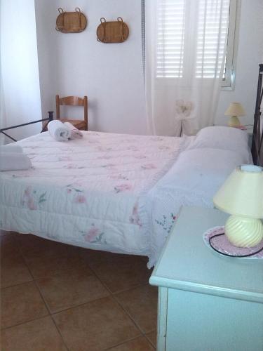 a bedroom with a bed and a table with a lamp at Appartamenti Claudia Rio in Rio Marina