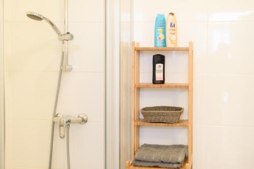 ウィーンにあるVienna Living Apartments - Erlachgasseのバスルーム(木製の棚、タオル、シャワー付)