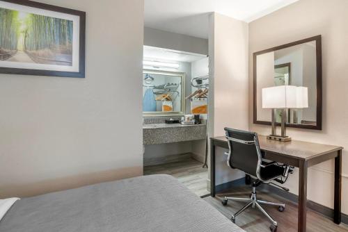 a bedroom with a desk and a bed and a lamp at Quality Inn Simpsonville-Greenville in Simpsonville