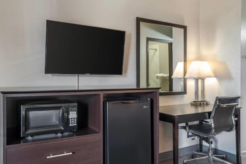 a hotel room with a microwave and a desk with a television at Quality Inn Simpsonville-Greenville in Simpsonville