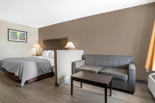 a hotel room with a bed and a couch at Quality Inn Simpsonville-Greenville in Simpsonville