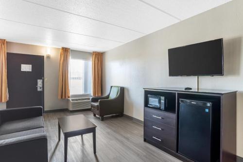 a hotel room with a tv and a couch and a chair at Quality Inn Simpsonville-Greenville in Simpsonville