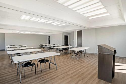 a classroom with white tables and chairs and a podium at Quality Inn Simpsonville-Greenville in Simpsonville