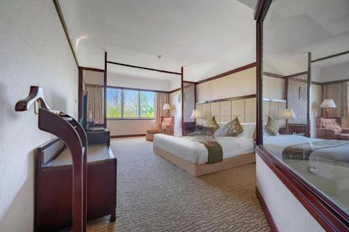 a hotel room with two beds and a mirror at Wonderport International Hotel in Lijiang