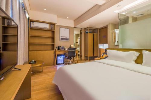 a hotel room with a bed and a desk at V8 Ziyuangang Hotel in Guangzhou