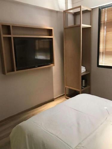 a bedroom with a white bed and a window at V8 Ziyuangang Hotel in Guangzhou