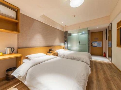 a bedroom with two beds in a room at V8 Ziyuangang Hotel in Guangzhou
