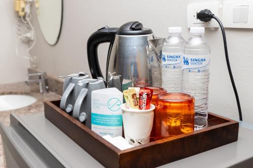 a tray with drinks and other items on a counter at Recenta Suite Phuket Suanluang in Phuket Town