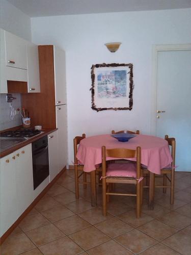 a kitchen with a table with a pink table cloth on it at Appartamenti Claudia Rio in Rio Marina