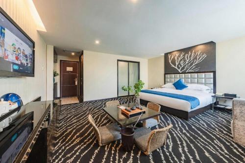 a hotel room with a bed and a flat screen tv at Kunming Long Way Hotel in Kunming