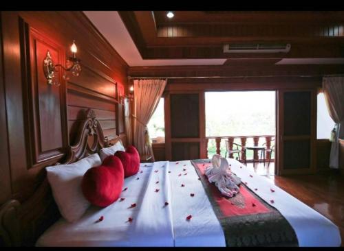 a bedroom with a bed with red apples on it at Ngamta Hotel in Mae Hong Son
