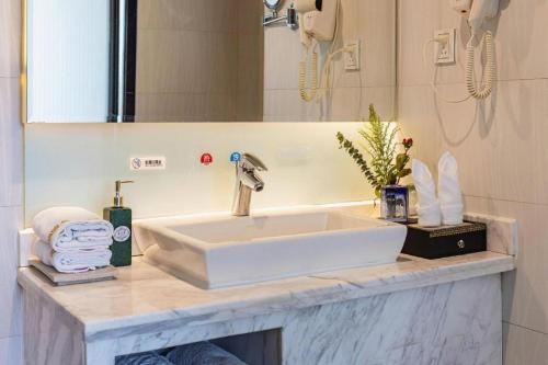 a bathroom counter with a sink and a mirror at Kunming Long Way Hotel in Kunming