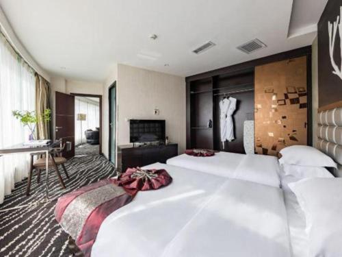 a hotel room with two beds and a television at Kunming Long Way Hotel in Kunming