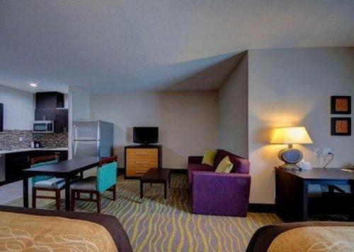a hotel room with a bed and a dining room at Comfort Inn & Suites Tulsa I-44 West - Rt 66 in Tulsa