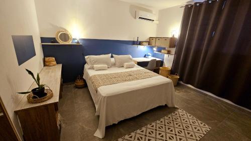 a bedroom with a bed and a blue wall at Tiavairai Airport in Faaa