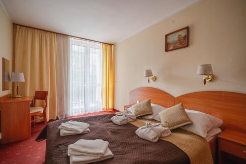 a hotel room with a bed with towels on it at Kompleks Antałówka Termy & Med in Zakopane