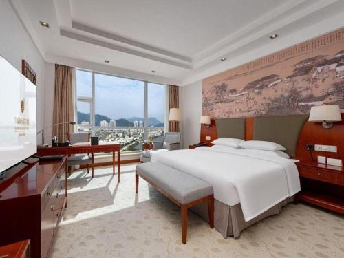 a large bedroom with a large bed and a piano at New Century Grand Hotel Ninghai Jinhai in Shang-ts'un