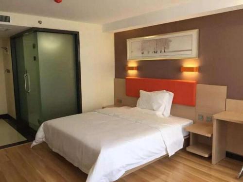 a bedroom with a white bed and a green door at 7 Days Premium Tangshan Railway Station Jiaotong University in Tangshan