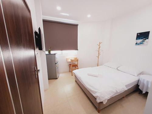 a bedroom with a bed and a table and a chair at Yen Minh Resthouse in Ho Chi Minh City