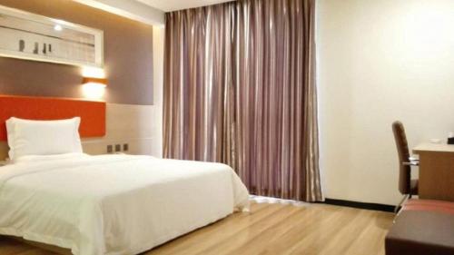 a bedroom with a large white bed and a desk at 7 Days Premium Tangshan Railway Station Jiaotong University in Tangshan