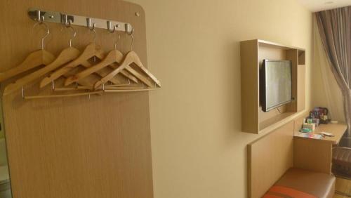 a room with a closet with hangers and a tv at 7 Days Premium Tangshan Railway Station Jiaotong University in Tangshan