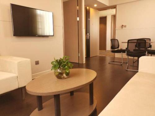 a living room with a couch and a table at Jinjiang Inn Select Kunming High-speed South Railway University Town in Kunming