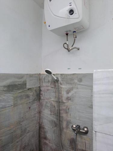 a shower in a bathroom with a camera on the wall at Lavender star house in Kuta