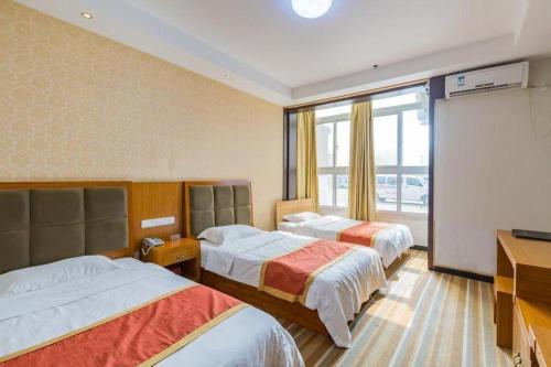 北京市にある169 Business Hotelのベッド2台とテレビがあるホテルの部屋