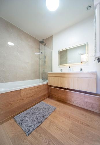 un bagno con doccia, vasca e specchio di Le paddock a Chagny