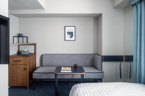 a room with a couch and a table with a bed at Hotel Starplaza Ikebukuro in Tokyo