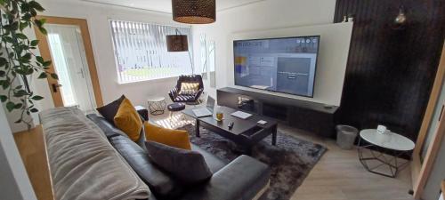 a living room with a couch and a flat screen tv at Modern flat in quiet residential cul-de-sac in Kilwinning