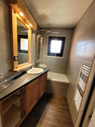 une salle de bain avec un lavabo et une baignoire dans l'établissement Résidence Marcelly - appartement centre station, entièrement rénové, classé 3 étoiles MAE-0791, aux Gets