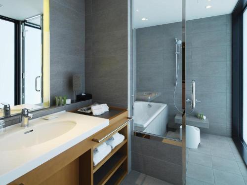 a bathroom with a sink and a shower and a tub at Nippondaira Hotel in Shizuoka