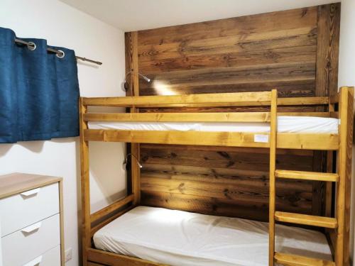 Ce lit se trouve dans un dortoir doté de 2 lits superposés et de murs en bois. dans l'établissement Résidence Le Solaret - Appartement centre village pour 4 personnes MAE-0821, aux Gets