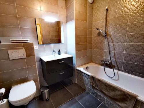 une salle de bain avec une baignoire, des toilettes et un lavabo dans l'établissement Chalet Ines - Appartement spacieux avec jardin MAE-0921, aux Gets