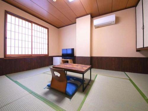 a room with a table and a chair in it at Business Hotel Wako in Ichinomiya