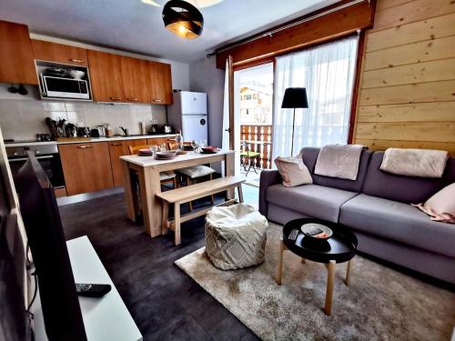 un salon avec un canapé et une cuisine dans l'établissement Résidence Chanteneige - Appartement lumineux et rénové MAE-1181, aux Gets