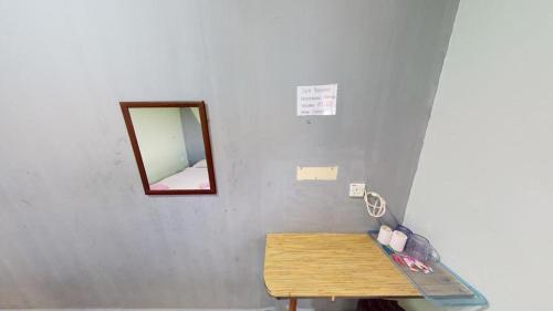 a mirror on a wall next to a wooden table at Hotel Tuaran in Kota Kinabalu