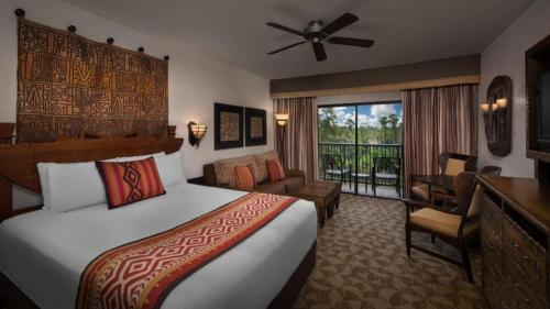 a hotel room with a bed and a balcony at Disney's Animal Kingdom Villas - Jambo House in Orlando