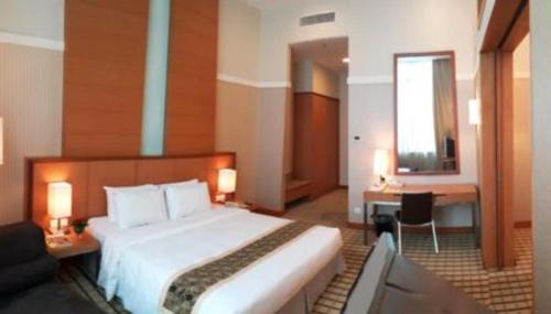 a hotel room with a large bed and a mirror at RH Hotel Sibu in Sibu