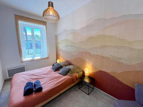 une chambre avec un lit avec un tableau sur le mur dans l'établissement Le Riquet - Parking et jardin privé, clim, RDC, à Castelnaudary