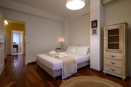a bedroom with a large white bed and a dresser at Casa Constantine Spacious Family and Friends Oasis with Pool, 10 Min from Kalamata in Andikálamos