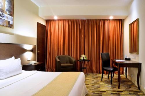 ジョージタウンにあるHotel Royal Penangのベッドと机があるホテルの部屋