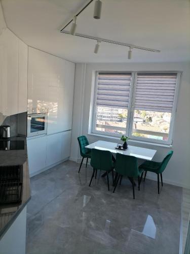 a kitchen with a white table and green chairs at MaFi apartment in Bitola