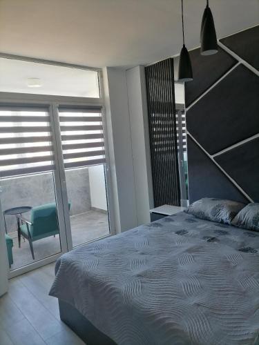 a bedroom with a large bed and a large window at MaFi apartment in Bitola