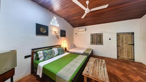 a bedroom with a bed and a ceiling fan at Wild Wadi Wilpattu - Villas with private Plunge Pools in Wilpattu