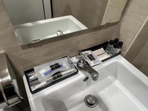 un lavandino del bagno con un rubinetto e uno specchio di V Plus Hotel Ipoh a Ipoh
