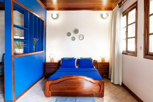 a bedroom with a bed with blue sheets at Maison Ubururu in Kigali