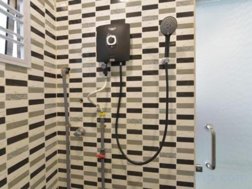 ein Badezimmer mit Dusche mit Duschkopf in der Unterkunft OYO 90889 Narasindo Cottage in Kuala Lumpur